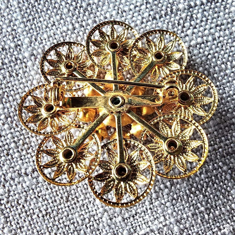 Vintage aurora borealis rhinestone gold-tone filigree floral brooch. 1960's